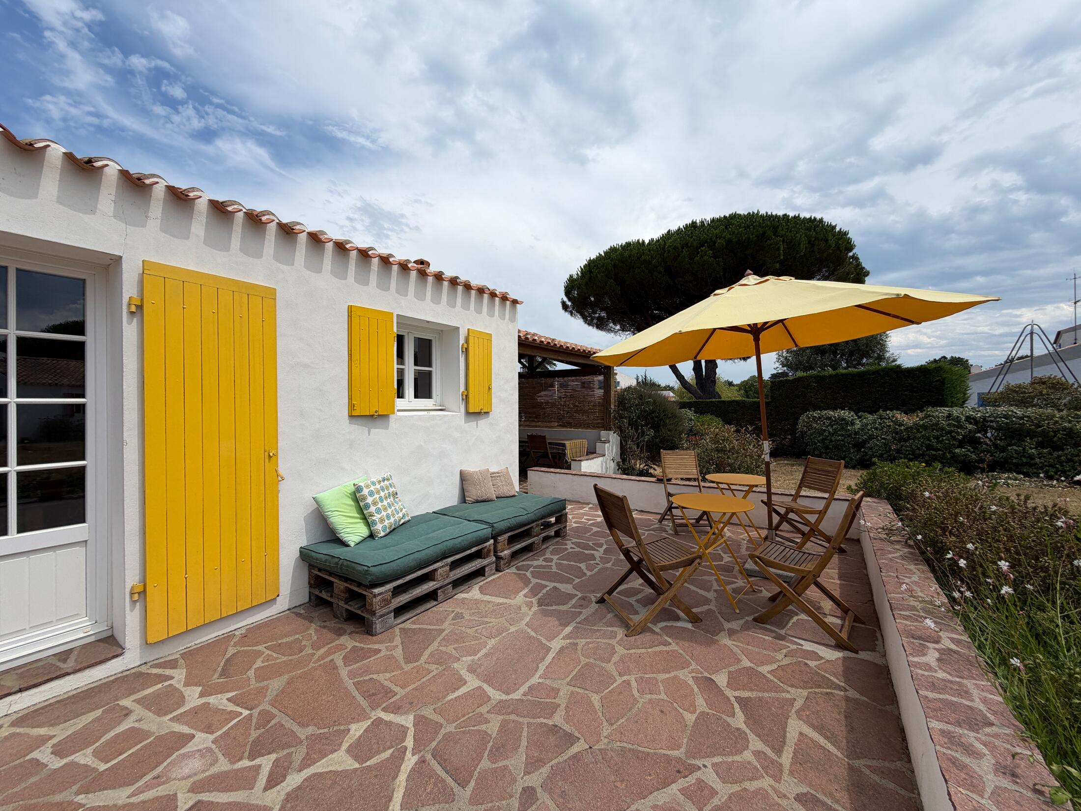 Terrasse mit Sonnenschirm, Sitzecke und Lounge-Bereich